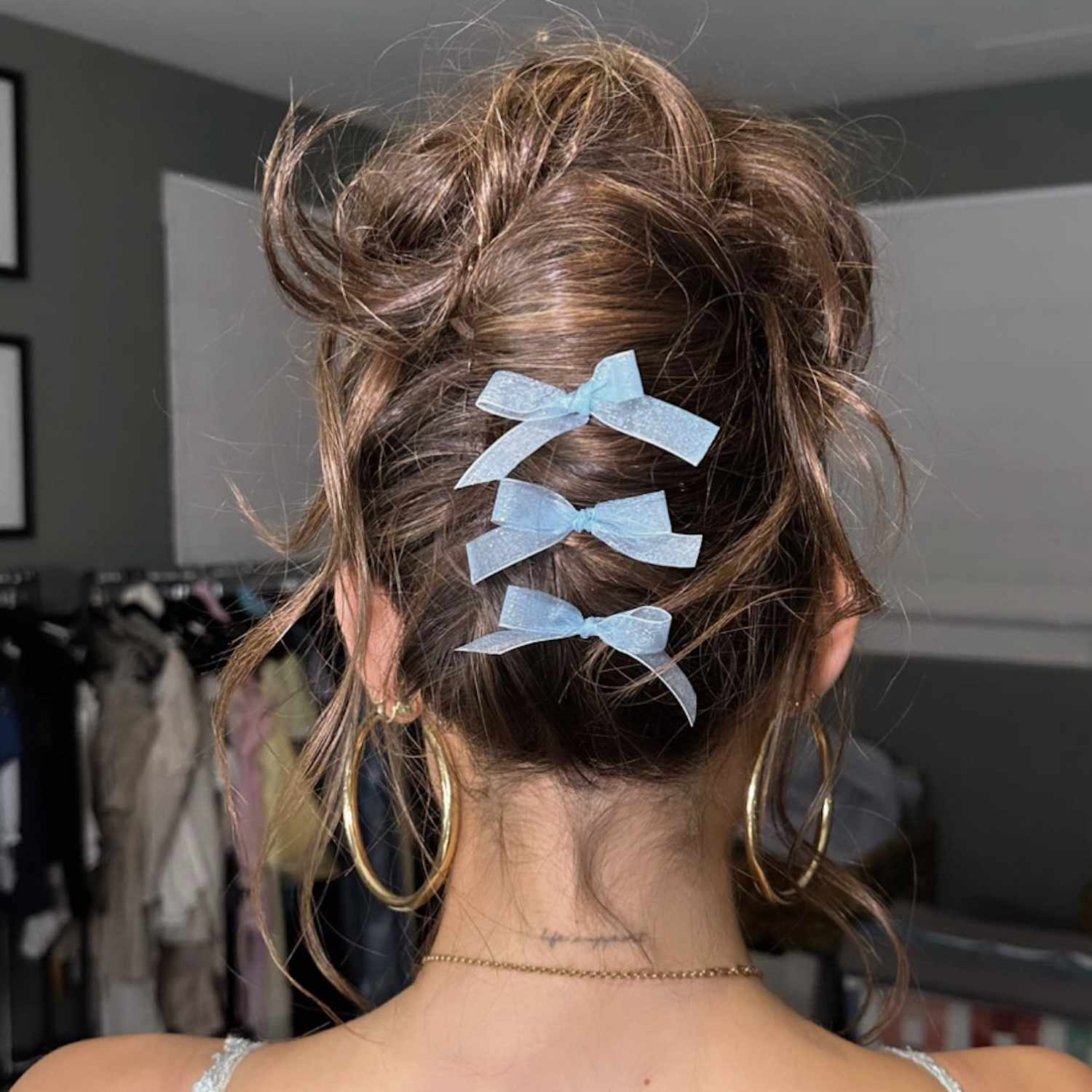 Back view of Madison Beer with twisted updo with light blue ribbons