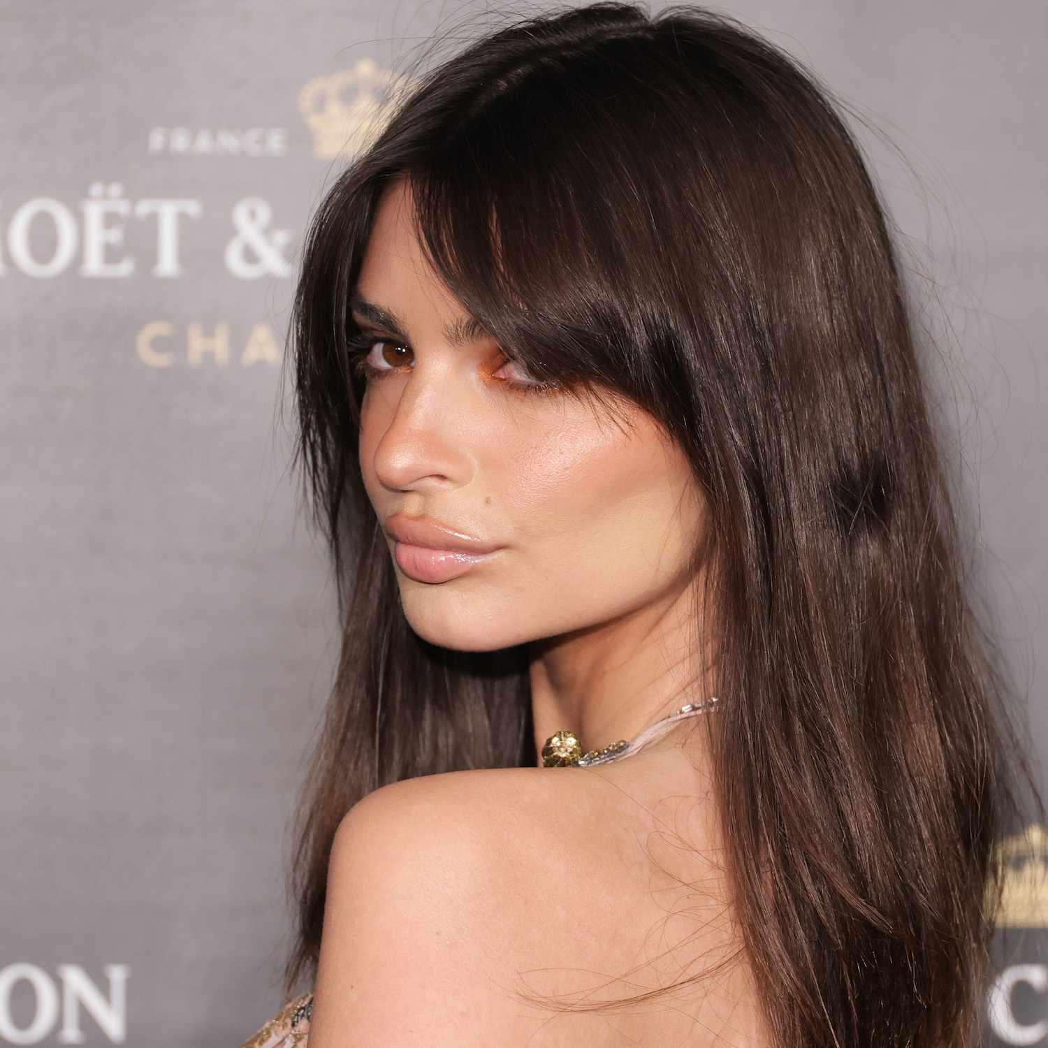 Emily Ratajkowski wears a long hairstyle with face-framing layers and curtain bangs