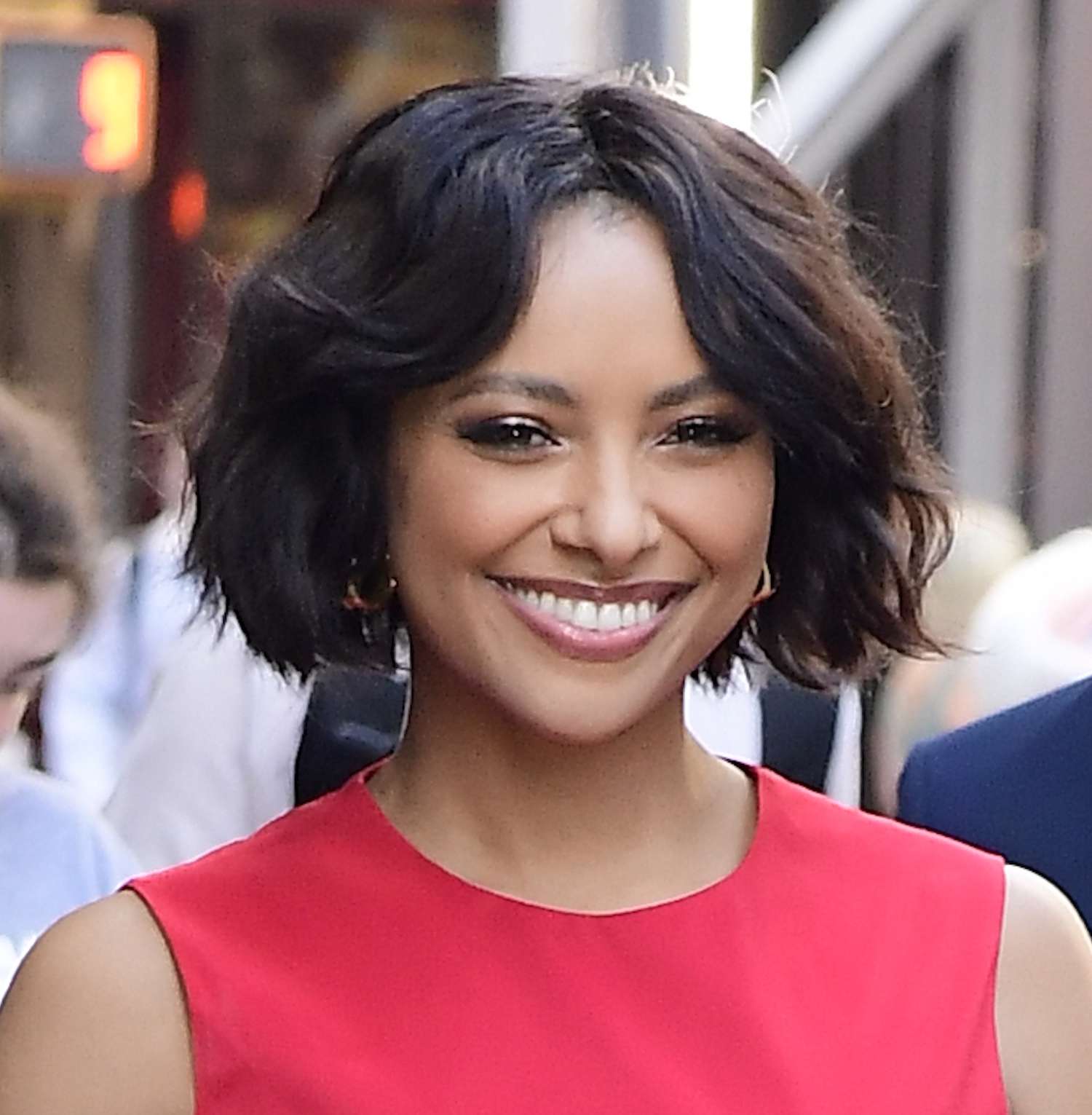 Kat Graham wears a wavy bob hairstyle and red dress