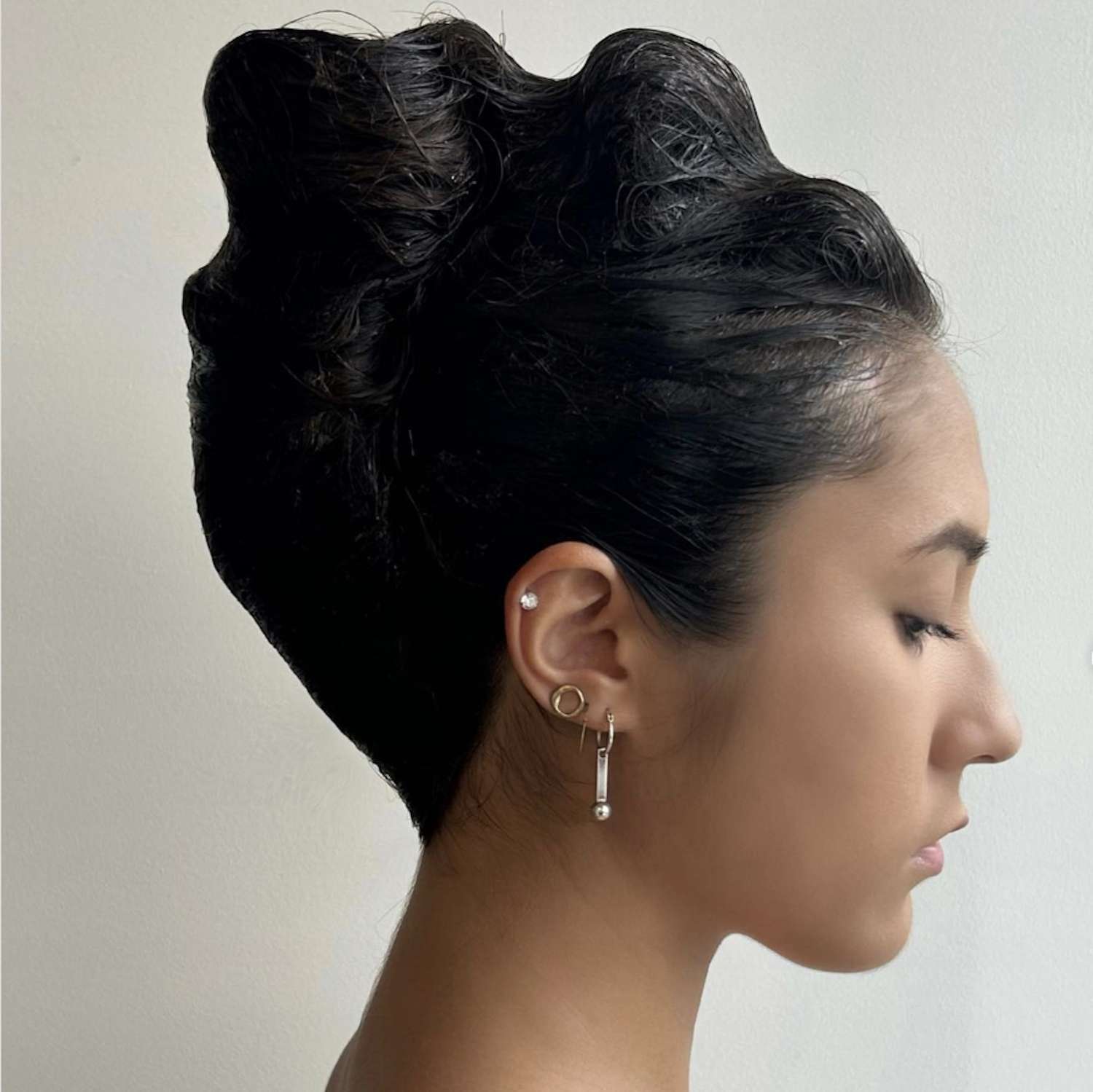 Side view of woman with voluminous French twist hairstyle with dramatic wavy bumps