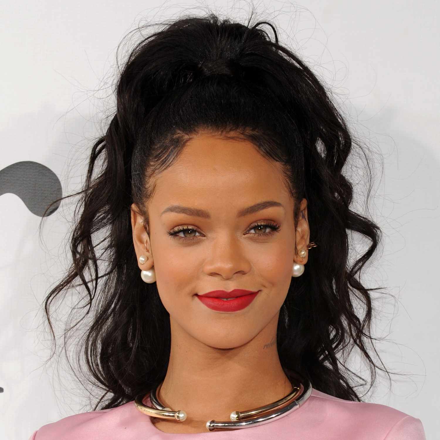 Rihanna wears a high ponytail hairstyle with teased roots and curls