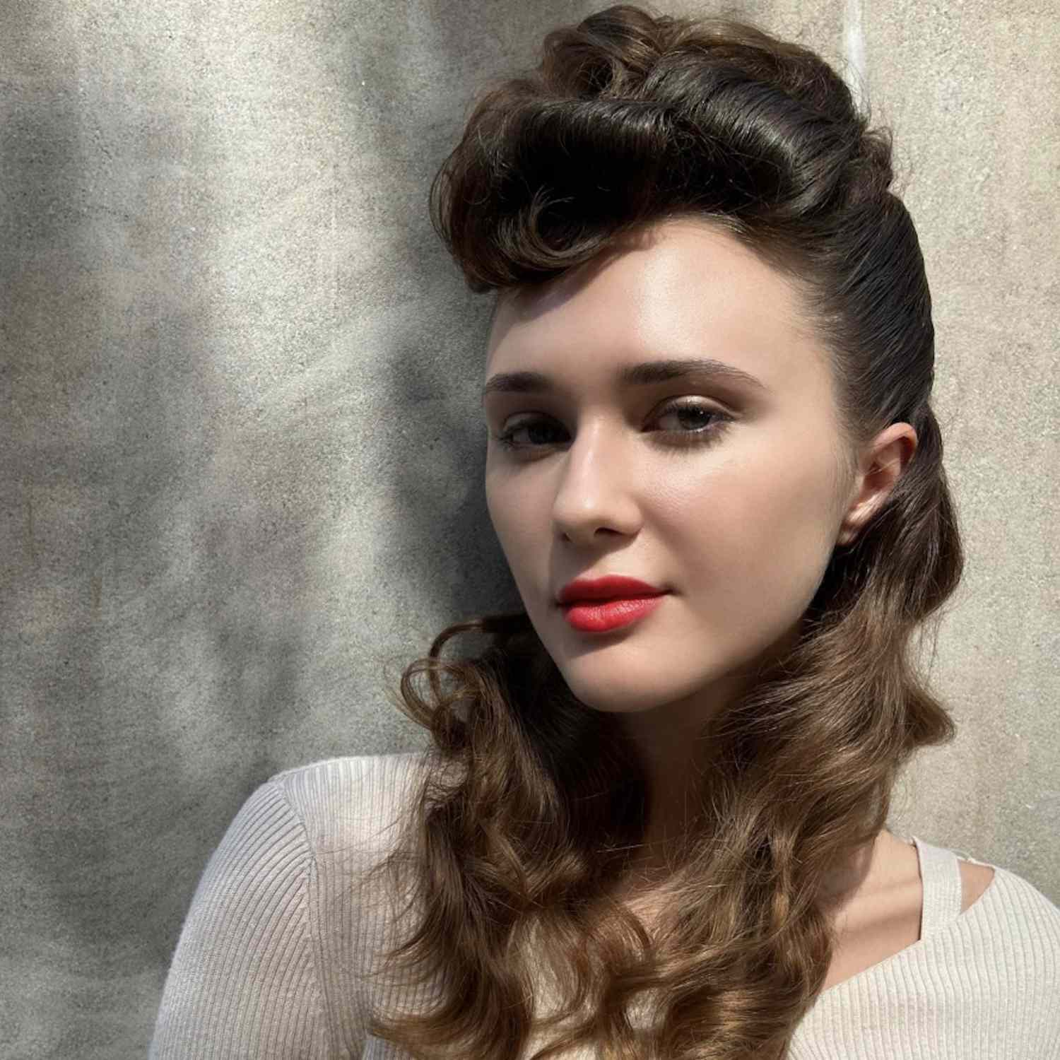 Close-up of woman with voluminous wavy half-up hairstyle and red lipstick