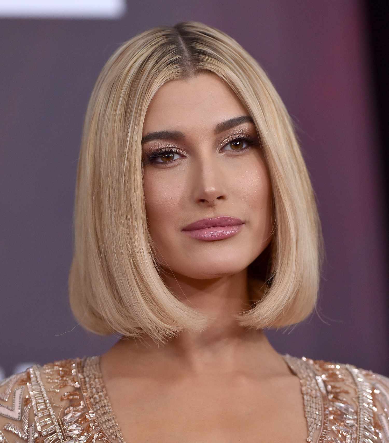 Hailey Bieber wearing a curved voluminous bob hairstyle and radiant makeup look