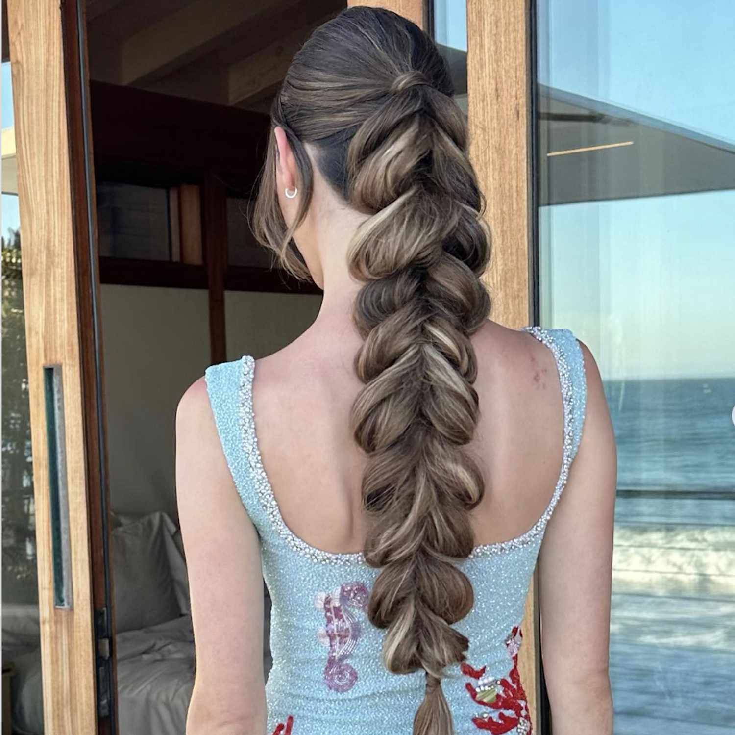 Back view of woman with voluminous, long, puffy braid hairstyle