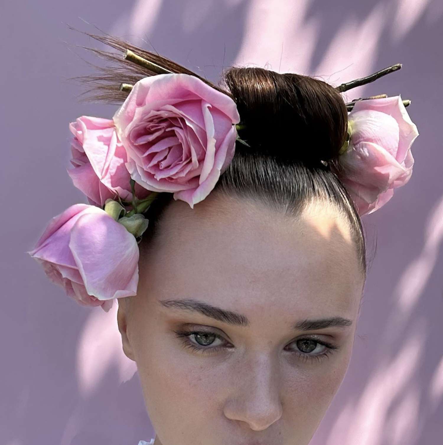 Close-up of woman with updo hairstyle with sticks and oversized roses
