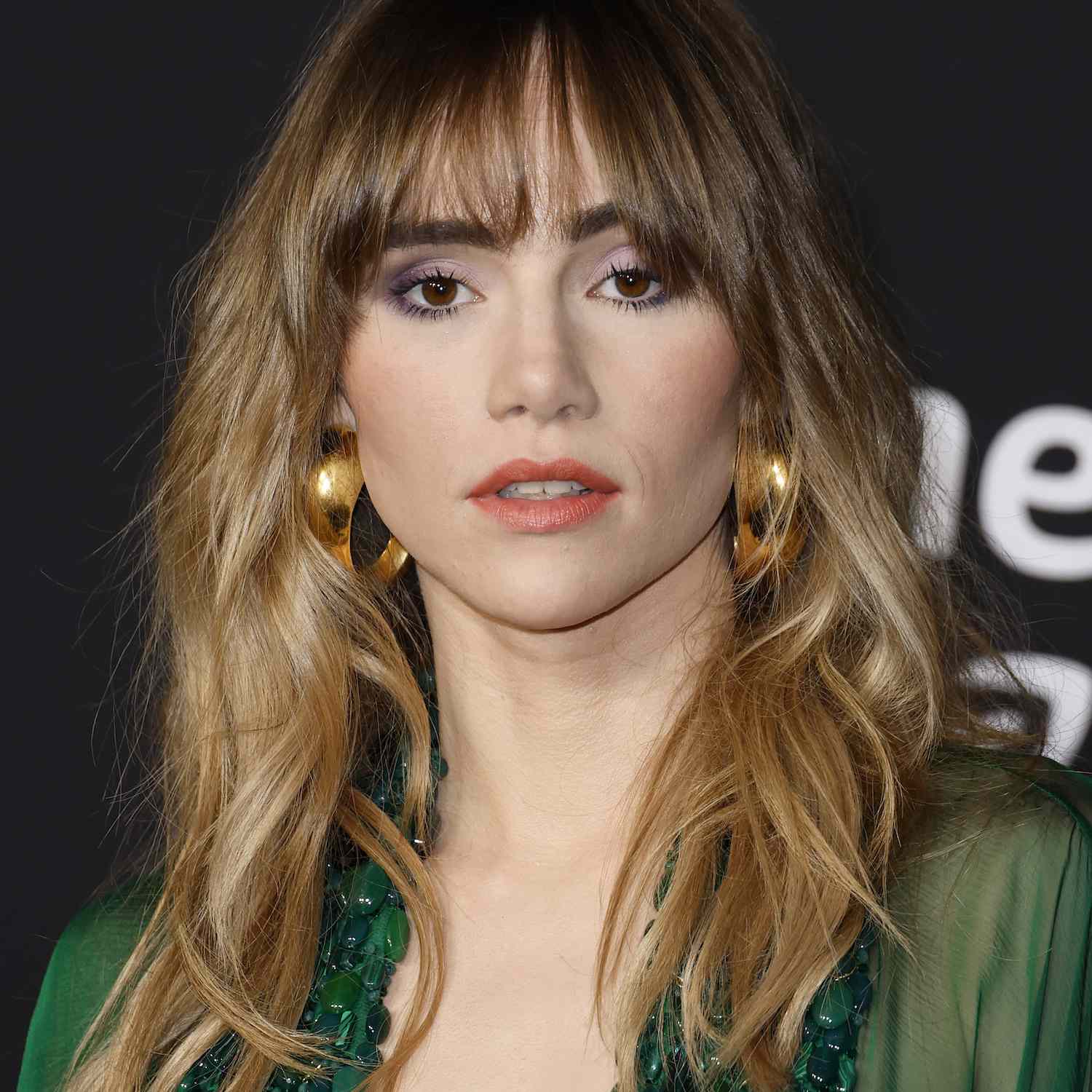 Suki Waterhouse wears a tousled ombre hairstyle with bangs