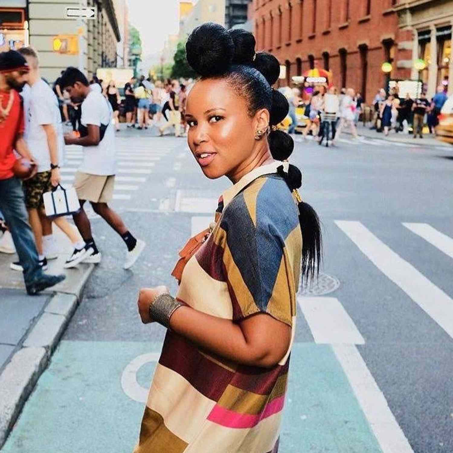 Tiffany Battle wears a mohawk-inspired bubble ponytail hairstyle and multicolored t-shirt dress