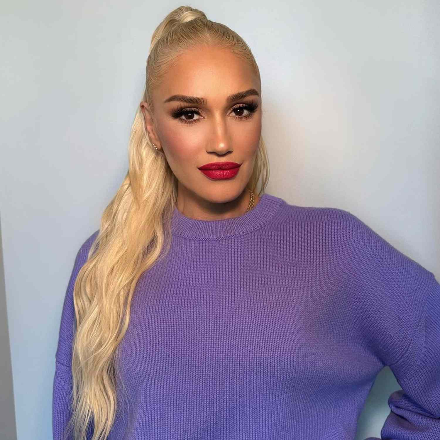 Gwen Stefani wears a high ponytail hairstyle with sleek roots and wavy ends
