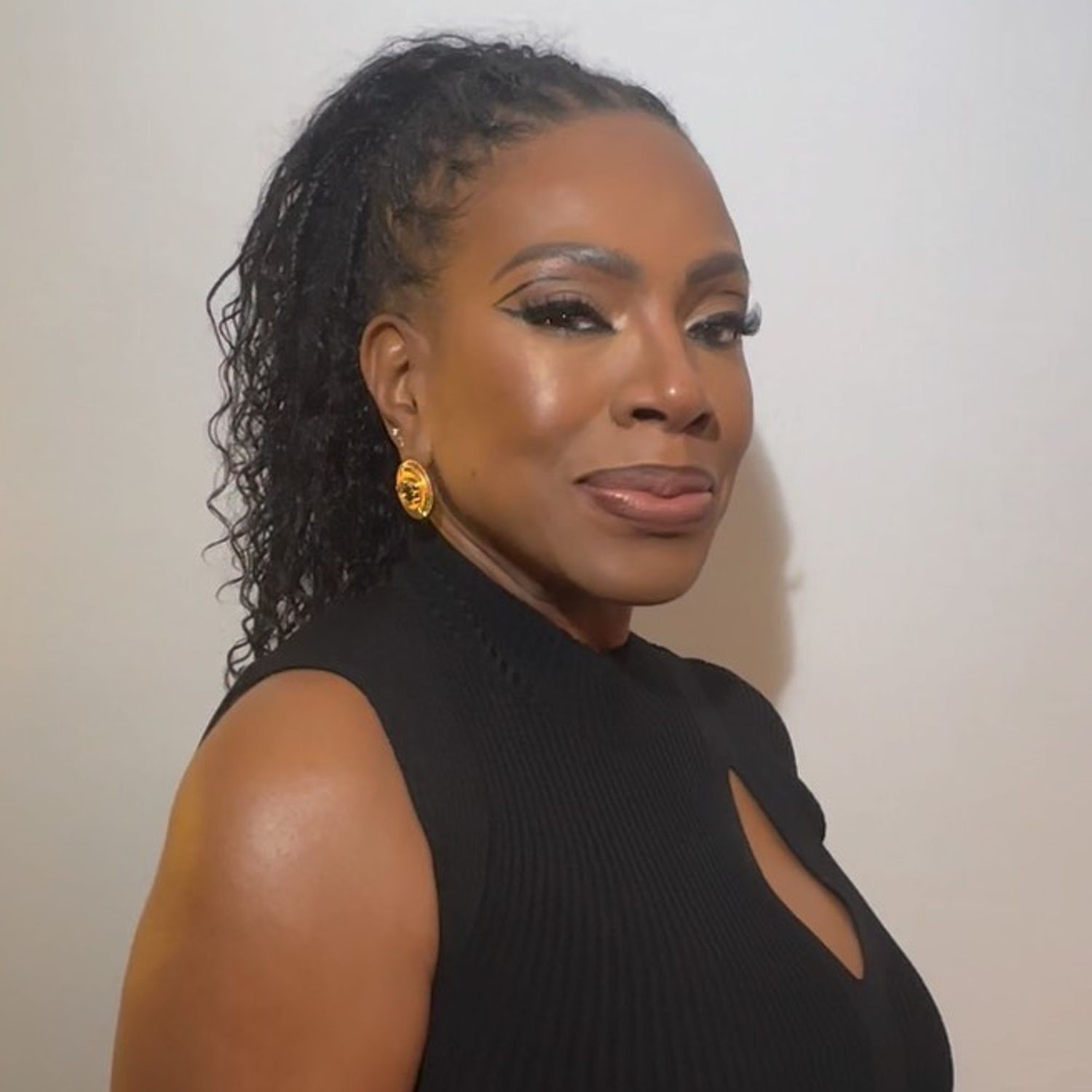 Sheryl Lee Ralph wears a curly ponytail hairstyle with cornrowed roots and graphic eye makeup