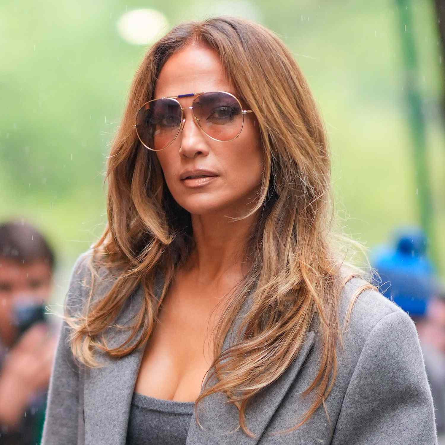Jennifer Lopez wears a '70s-inspired blowout with face-framing layers and aviator sunglasses