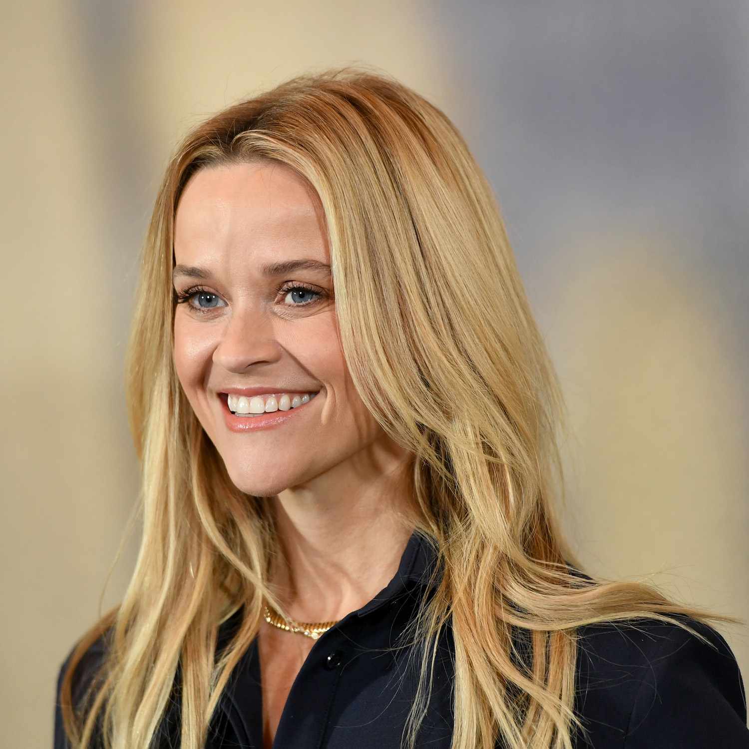Reese Witherspoon wears a medium-length hairstyle with soft, face-framing layers