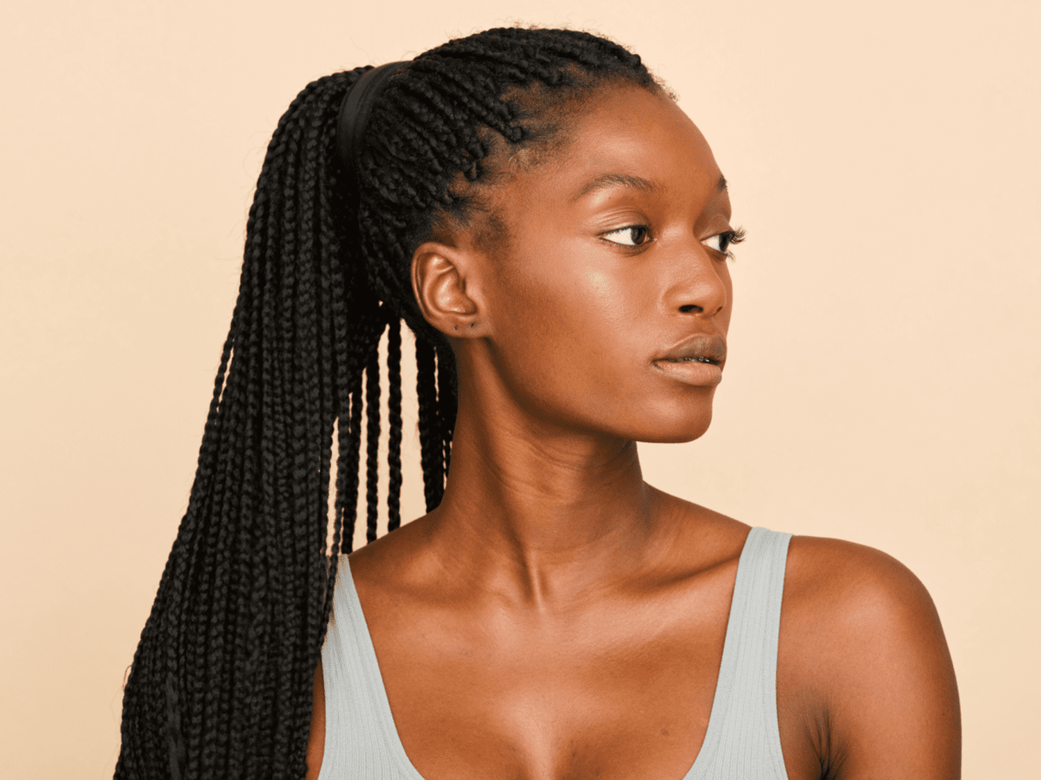 A Black model with braids in a ponytail, from the side profile